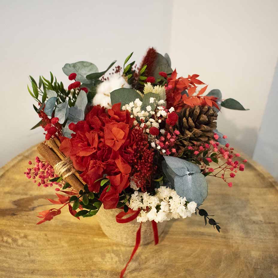 cesto navideño de flores rojas con algodón y canela