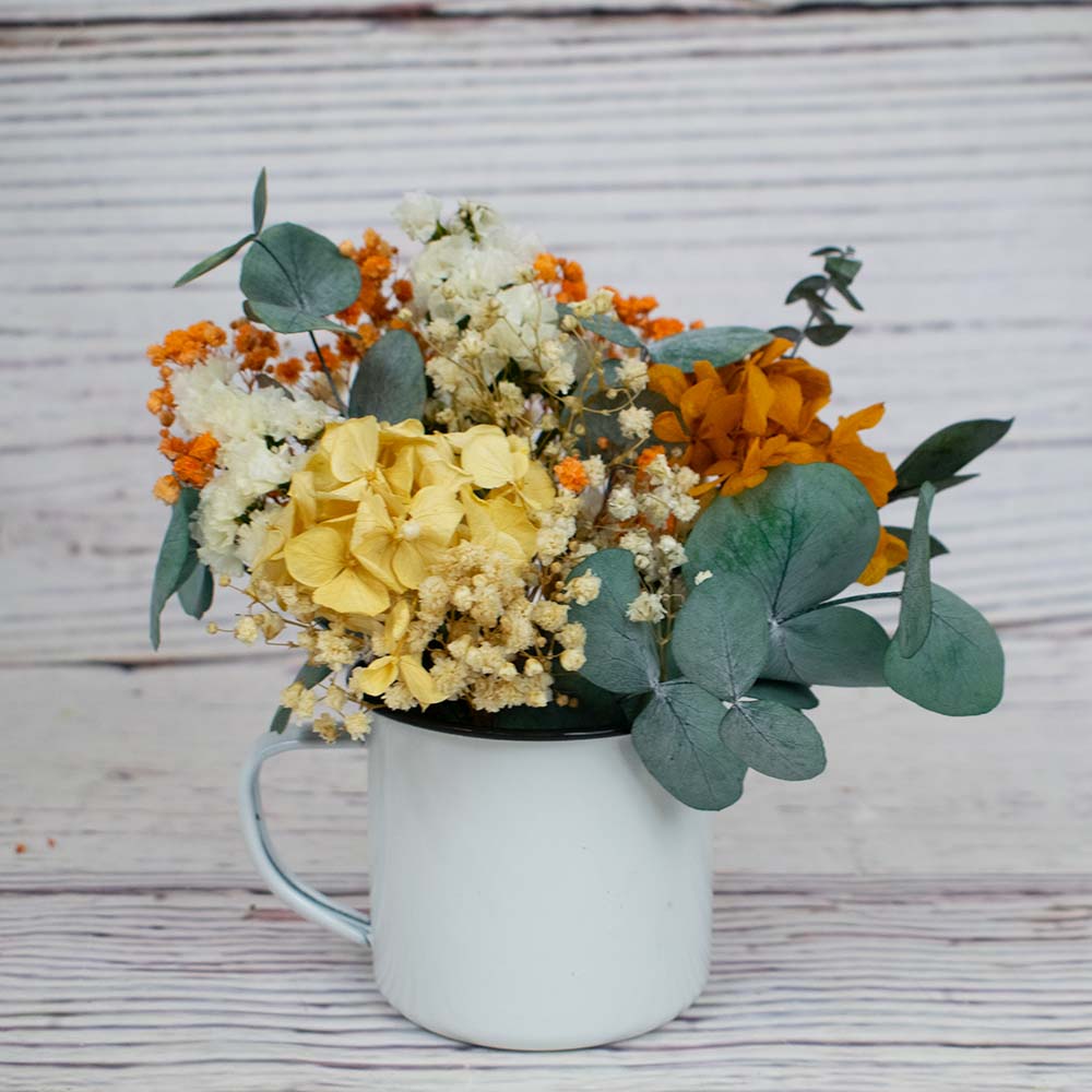 Taza con flores de hortensias anaranjadas y amarillas

