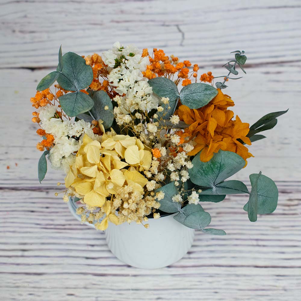 Taza con flores de hortensias anaranjadas y amarillas
